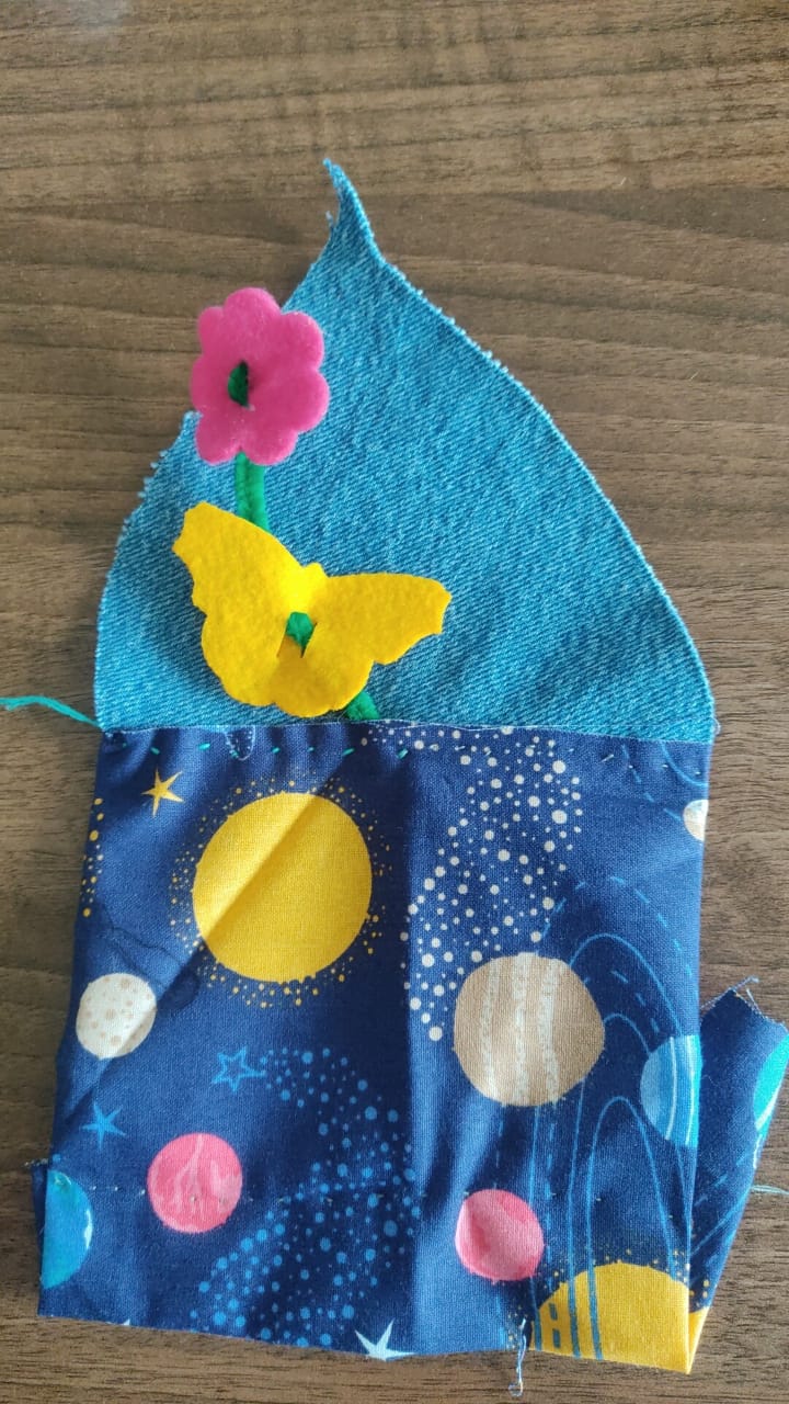 Clothe leaf. It has a lower inside pocket. The cloth is a mix of blue jean recycled cloth and cloth that has a space-themed pattern.
